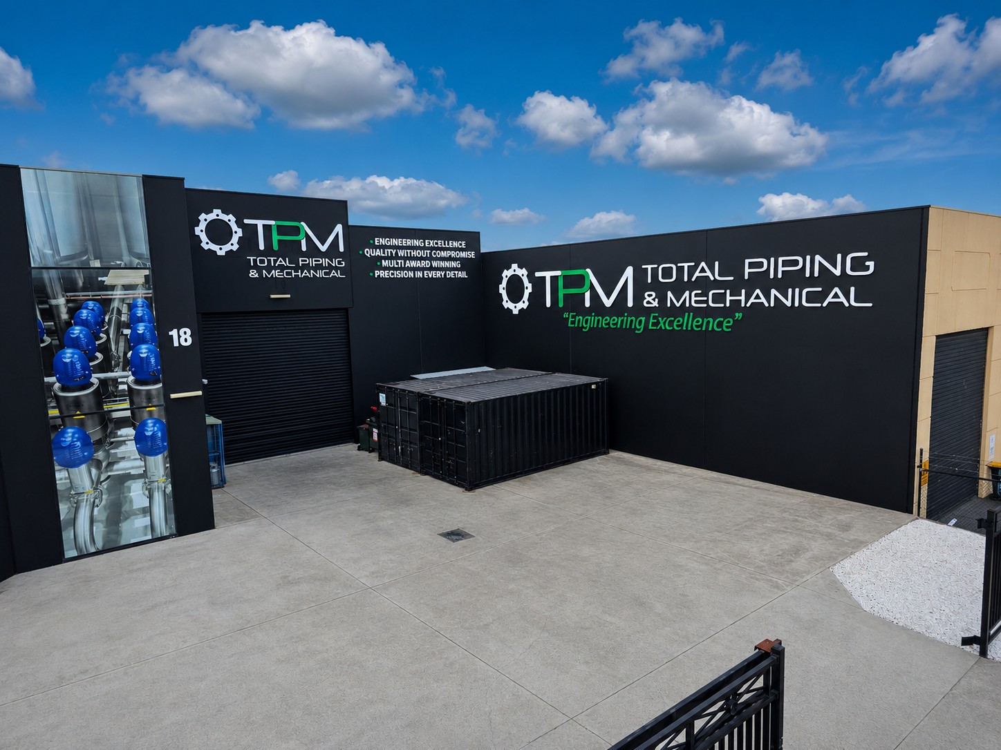 Wide exterior view of TPM Total Piping and Mechanical workshop branding